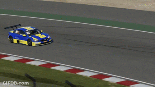 A Blue And Yellow Race Car Is Driving Down A Road GIF