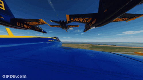 A Blue And Yellow U.s. Navy Jet Is Flying Over A Field GIF