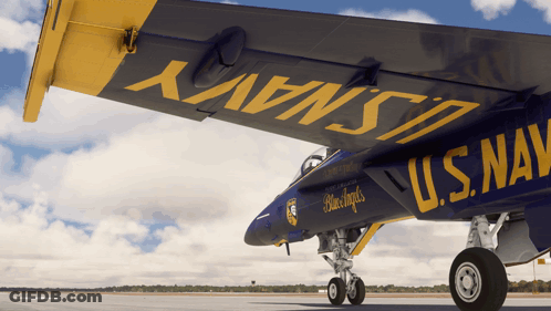 A Blue And Yellow U.s. Navy Jet Is Parked On The Runway GIF
