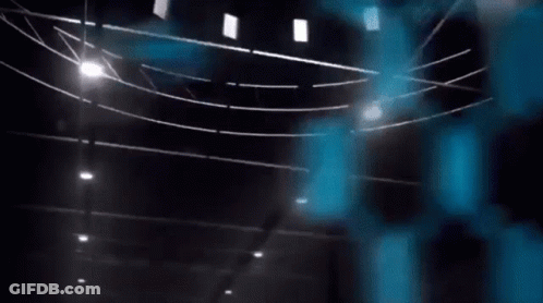 A Blue Bird Is Flying In The Air In Front Of A Blue Hexagon Wall . GIF