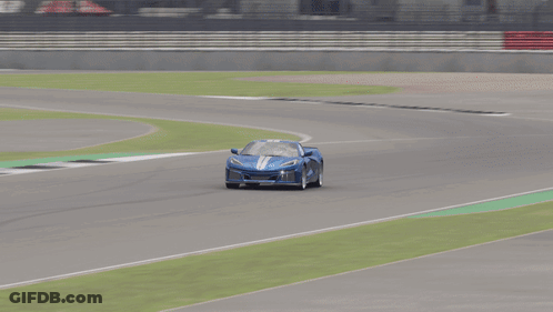 A Blue Car Is Driving Down A Race Track With A Sign That Says E On It GIF