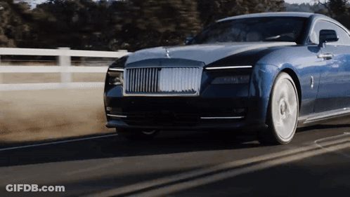 A Blue Car Is Driving Down A Road With A Fence In The Background GIF