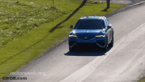 A Blue Car Is Driving Down A Road With Motorweek.org Written On The Bottom Right GIF