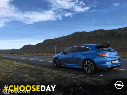 A Blue Car Is Driving Down A Road With Mountains In The Background And The Hashtag #Chooseday GIF