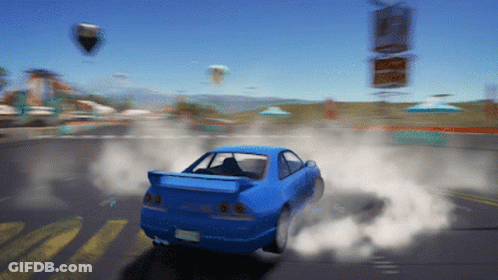 A Blue Car Is Driving Down A Road With Smoke Coming Out Of The Tire GIF
