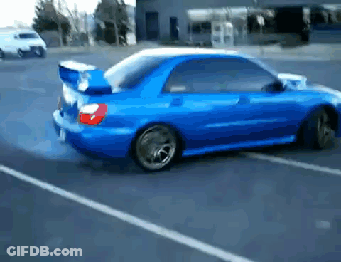 A Blue Car Is Driving Down A Street With Smoke Coming Out Of The Tires GIF