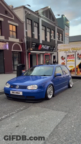 A Blue Car Is Parked In Front Of A Building That Says Pulse On It GIF