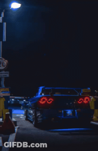 A Blue Car Is Parked In Front Of A Sign That Says 20 On It GIF
