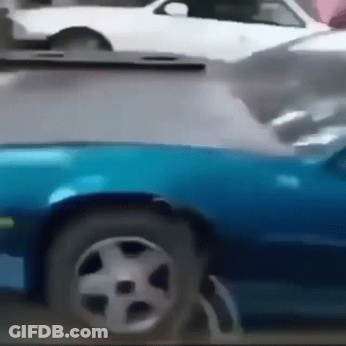 A Blue Car Is Parked Next To A White Car On A Street GIF
