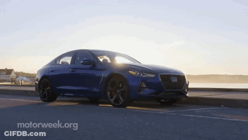 A Blue Car Is Parked On The Side Of The Road With Motorweek.org In The Corner GIF