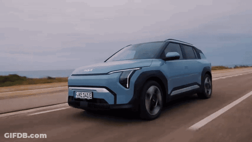 A Blue Car With A License Plate That Says Ehz-414E Is Driving Down A Road GIF