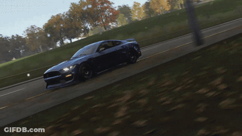 A Blue Car With A Red Stripe On The Front Is Driving Down A Road GIF