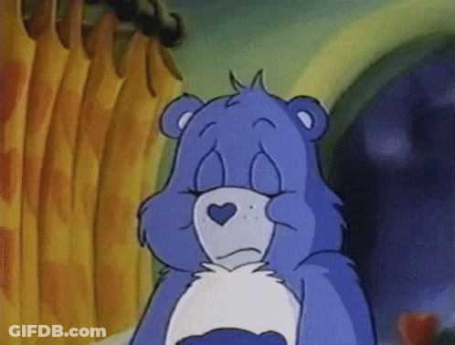 A Blue Care Bear With A Heart On Its Chest Looks Sad GIF