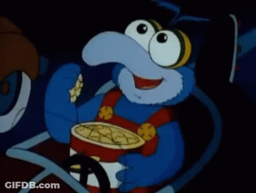 A Blue Cartoon Character Is Eating Popcorn In A Car . GIF