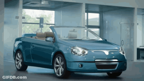 A Blue Convertible Is Parked In A Garage GIF