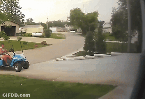 A Blue Golf Cart Is Parked In A Driveway GIF