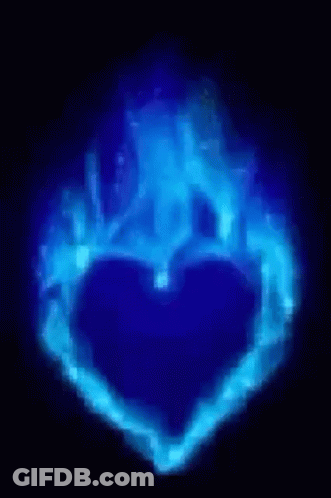 A Blue Heart Shaped Object Is Glowing In The Dark GIF