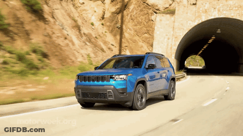 A Blue Jeep Drives Through A Tunnel On A Road GIF