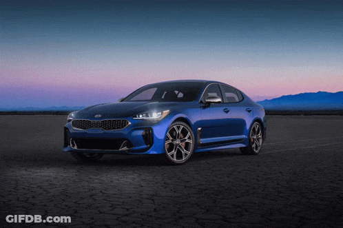 A Blue Kia Car Is Parked On A Dirt Road At Night GIF
