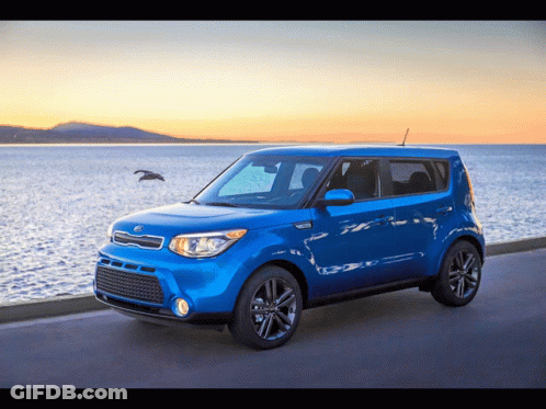 A Blue Kia Soul Is Parked On The Side Of A Road Near The Ocean GIF