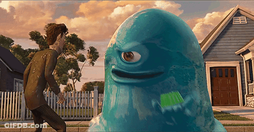 A Blue Monster With A Single Eye Is Standing In Front Of A House GIF