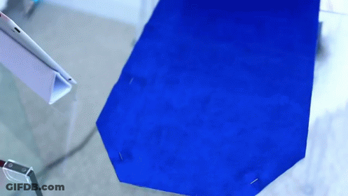 A Blue Piece Of Fabric Is Pinned To A Glass Surface GIF