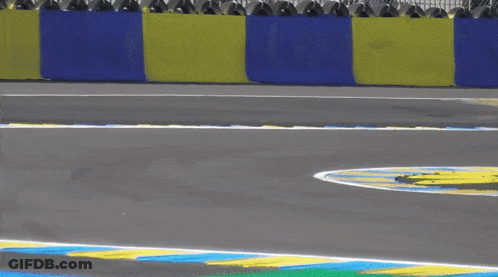A Blue Race Car Is Going Around A Curve On A Race Track GIF