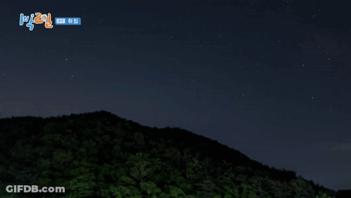 A Blue Sky With A Mountain In The Foreground And Korean Writing On The Bottom GIF