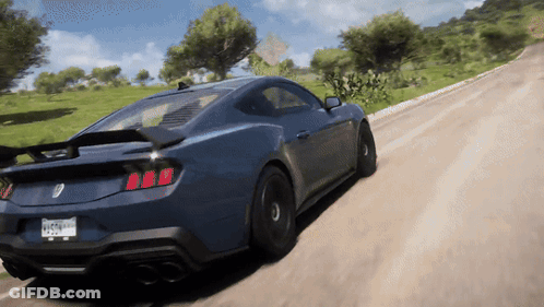A Blue Sports Car Is Driving Down A Dirt Road With A California License Plate GIF