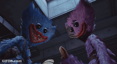 A Blue Stuffed Animal And A Purple Stuffed Animal Standing Next To Each Other GIF