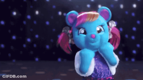 A Blue Teddy Bear With Pink Hair And A Purple Dress GIF