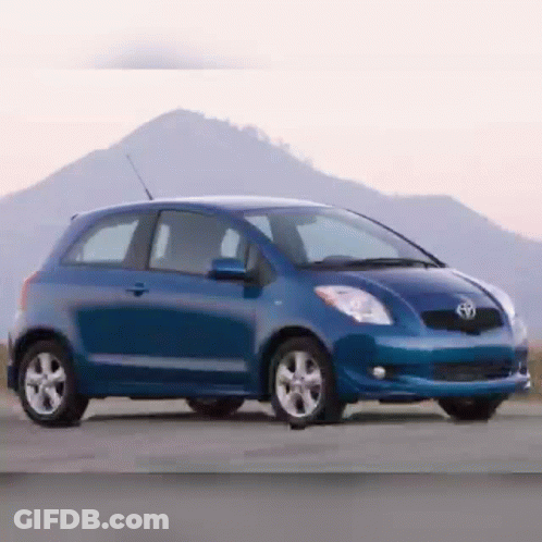 A Blue Toyota Car Is Parked On The Side Of A Road GIF