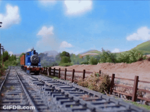 A Blue Train Is Going Down The Tracks In The Countryside GIF