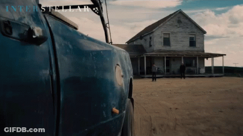 A Blue Truck Is Parked In Front Of A House With Interstellar Written On The Bottom GIF