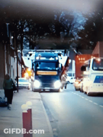 A Blue Truck Is Parked On The Side Of A Street GIF