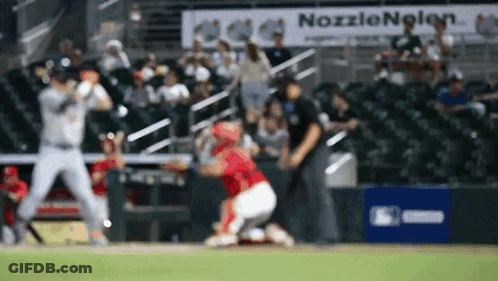 A Blurred Image Of A Baseball Game With A Nozzlenolen Sign In The Background GIF