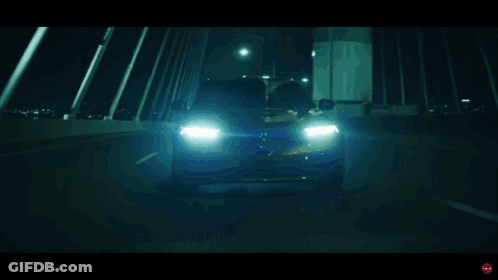 A Blurred Image Of A Car Driving Down A Road At Night GIF