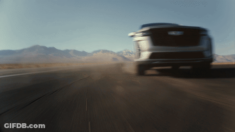 A Blurred Image Of A Car Driving Down A Road With Mountains In The Background GIF
