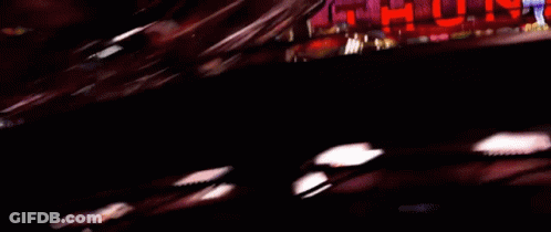 A Blurred Image Of A Car Driving Past A Sign That Says ' Urd ' GIF