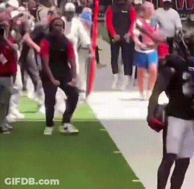 A Blurred Image Of A Crowd Of People Walking On A Green Carpet GIF