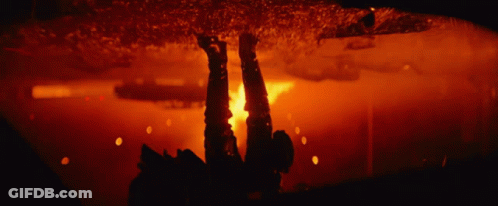 A Blurred Image Of A Fire In A Dark Room With A Red Background GIF
