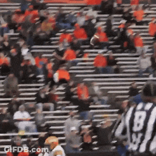 A Blurred Image Of A Football Stadium With A Referee Wearing A Black And White Uniform With The Number 60 On It GIF