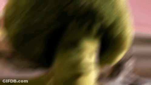A Blurred Image Of A Green Object With A Pink Background GIF