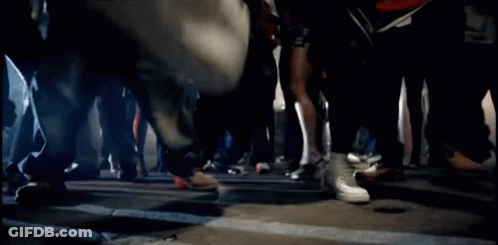 A Blurred Image Of A Group Of People Walking Down A Street GIF