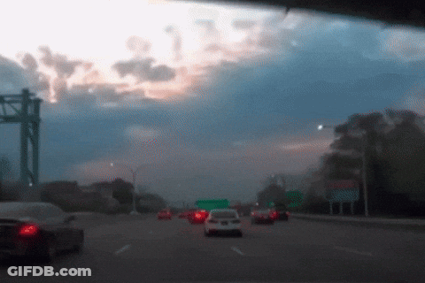 A Blurred Image Of A Highway With A Green Sign GIF
