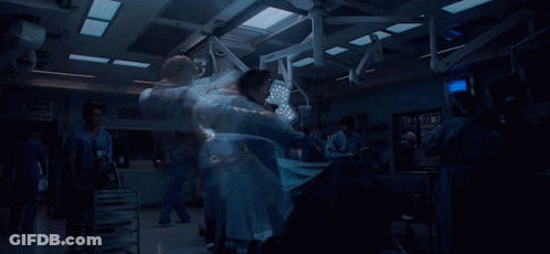 A Blurred Image Of A Hospital Operating Room With A Monitor That Shows The Time As 9:39 GIF