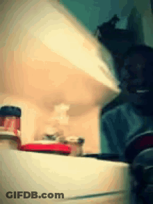 A Blurred Image Of A Kitchen With A Bottle Of Ketchup On The Counter GIF