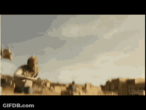 A Blurred Image Of A Man Kneeling In A Field With A Sign That Says ' Ranch ' On It GIF