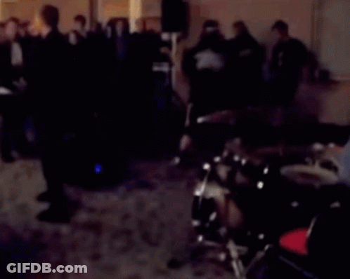 A Blurred Image Of A Man Playing Drums In A Dark Room GIF