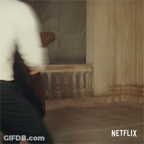 A Blurred Image Of A Man Walking With A Netflix Logo Behind Him GIF